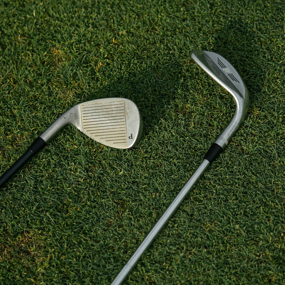 Two wedges lying on turf, soles up